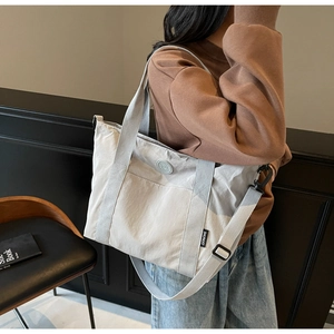 Gros plan sur un grand sac cabas en toile grise montrant sa texture et son étiquette