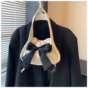 Détail du sac en velours avec grand nœud en tulle noir et bandoulière tissée