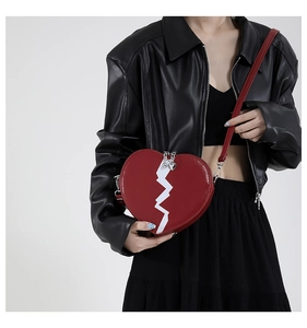Red heart-shaped crossbody bag with white zigzag stitch and silver heart zipper detail