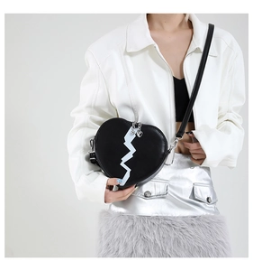 Detail of heart-shaped crossbody bag in black PU leather with white geometric pattern