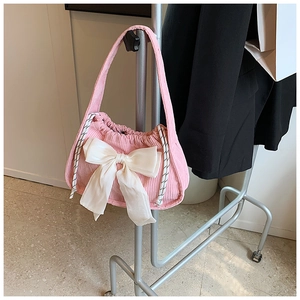 Détail du sac à main en velours côtelé rose avec un grand nœud en satin blanc