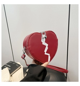 Detail of red heart-shaped shoulder bag with zigzag pattern and silver metal zipper