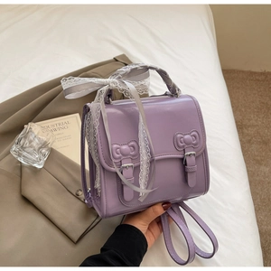 Detailed shot of lavender PU leather backpack with 3D bows and white lace ribbon