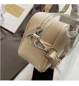 Close-up of premium silver hardware on a cream leather bag with lace ribbon detail