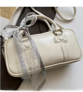 Detail of cream Boston bag with ribbon lace handles and 3D bow stitching texture