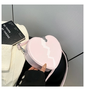Close-up of pink heart-shaped crossbody bag with white lightning texture and silver hardware