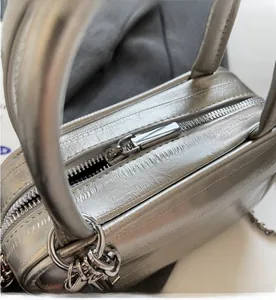 Dettaglio della cerniera metallica argento e pelle con stampa coccodrillo della borsa
