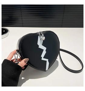 Detail of heart-shaped handbag with white lightning pattern and silver metal zipper
