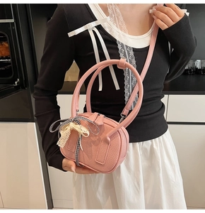 Dettaglio della borsa in pelle rosa con elegante fiocco in pizzo e nastro alla moda