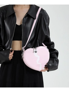 Pink heart-shaped crossbody bag with white crack pattern and leather jacket look