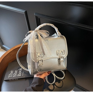 Detailed macro view of silver backpack with bow accents and lace ribbon handle