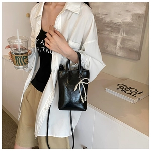 Sac seau chic en cuir noir avec nœud en perles et bandoulière chaîne pour femme