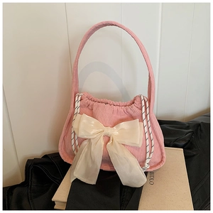 Détail du sac à main en velours côtelé rose avec grand nœud en satin blanc crème