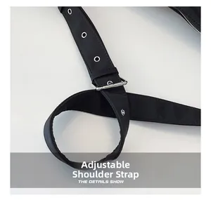 Detail shot of the adjustable shoulder strap with silver eyelets on a black hobo bag