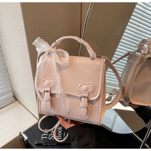Detail of pink PU leather backpack featuring magnetic bows and lace ribbon trim