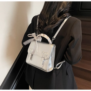 Silver mini backpack featuring lace-wrapped handle and elegant bow buckle details