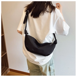 Detail of adjustable strap and silver buckle on large black minimalist crossbody bag