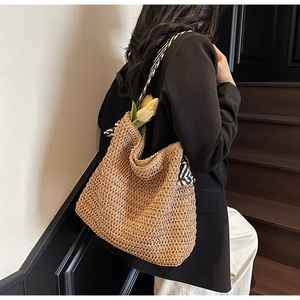 Détail du sac cabas en paille tissée avec bandoulière à rayures noires et blanches