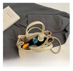 Detail view of the cream leather bucket bag interior showing spacious compartments