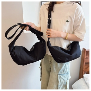 Detail of a large black vintage crescent bag featuring pleated nylon and adjustable strap