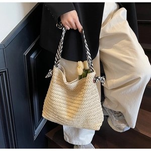 Détail du sac cabas en paille blanc cassé avec bandoulière rayée noire et blanche