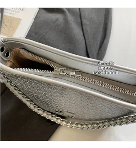 Detailed macro of smooth silver metal zipper and woven texture on bucket handbag