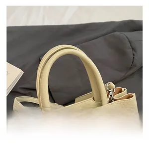 Detailed macro view of the cream leather texture and silver buckle on the stylish handbag