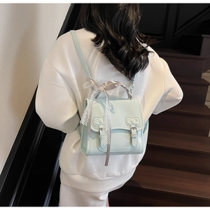 Detail of light blue bow backpack with lace ribbon and silver metallic buckle