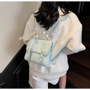 Detail of light blue PU leather backpack with bow relief and lace ribbon accessory