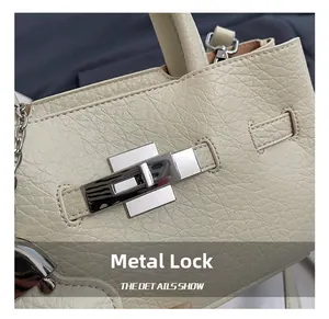 Close-up of cream pebble leather bucket bag with premium silver twist lock detail