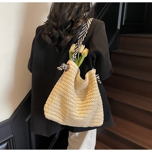 Détail du sac cabas en paille beige avec bandoulière à nœuds rayés et tulipes