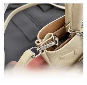 Detailed close-up of premium silver metal strap hooks and textured litchi leather grain