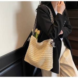 Détail du cabas en paille tressée beige avec anses en corde rayées noir et blanc