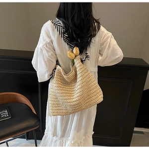 Détail du sac cabas en paille avec bandoulière large à motifs géométriques noirs et blancs