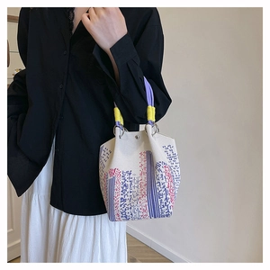 Canvas bucket bag detail met paarse touwhandvatten en kleurrijk abstract patroon