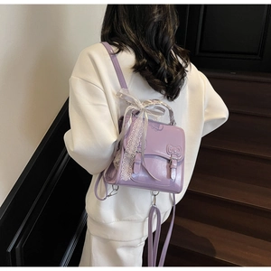 Rear view of a model wearing the purple PU leather backpack with delicate white lace details