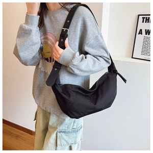Detail of black nylon crescent bag with wide adjustable shoulder strap and metal buckle