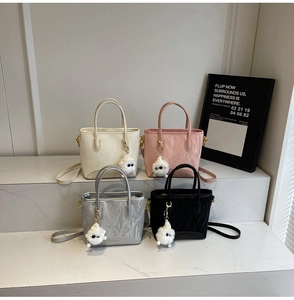 Détail de sacs seaux à texture froissée en quatre couleurs avec breloques en peluche
