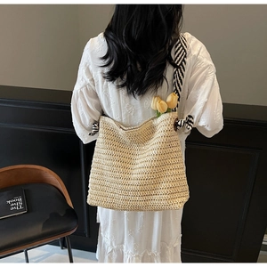 Détail du sac cabas en paille tressé beige avec bandoulière élégante rayée noir et blanc