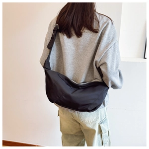 Detail of the black crescent dumpling bag showing durable nylon material and metal zipper
