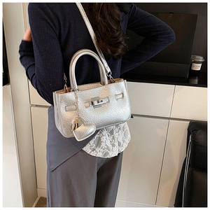 Detail of silver embossed leather bucket bag with heart pendant and twist lock closure