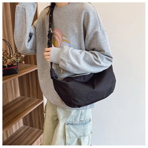 Close-up of a large black nylon dumpling bag with adjustable wide shoulder straps