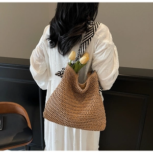 Détail du sac cabas en paille tissée avec bandoulière en toile rayée noir et blanc