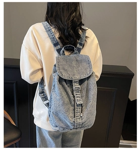 Vue détaillée d'un sac à dos en jean bleu avec boucles métalliques réglables au dos