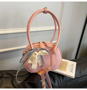 Dettaglio borsa bowling rosa in pelle martellata con fiocco in pizzo e doppia zip