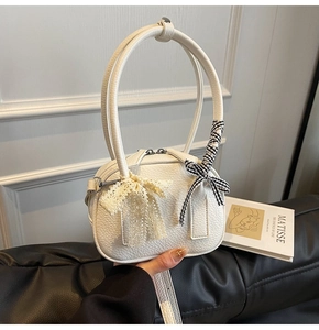 Dettaglio mini borsa bianca in pelle martellata con fiocchi in pizzo e a quadretti