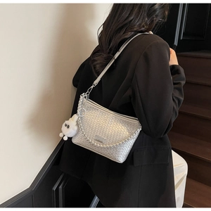 Detail of silver woven texture shoulder bag with metallic chain and ghost charm