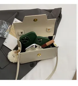 Vista interna della borsa a tracolla crema con spazio per telefono e rossetto