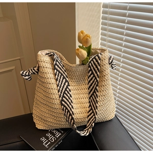 Détail du sac cabas en paille tissée avec bandoulière rayée et doublure intérieure en tissu