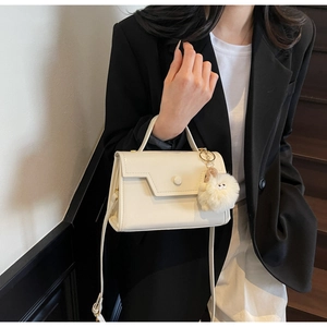 Borsa a tracolla bianco crema minimalista con un ciondolo decorativo in peluche